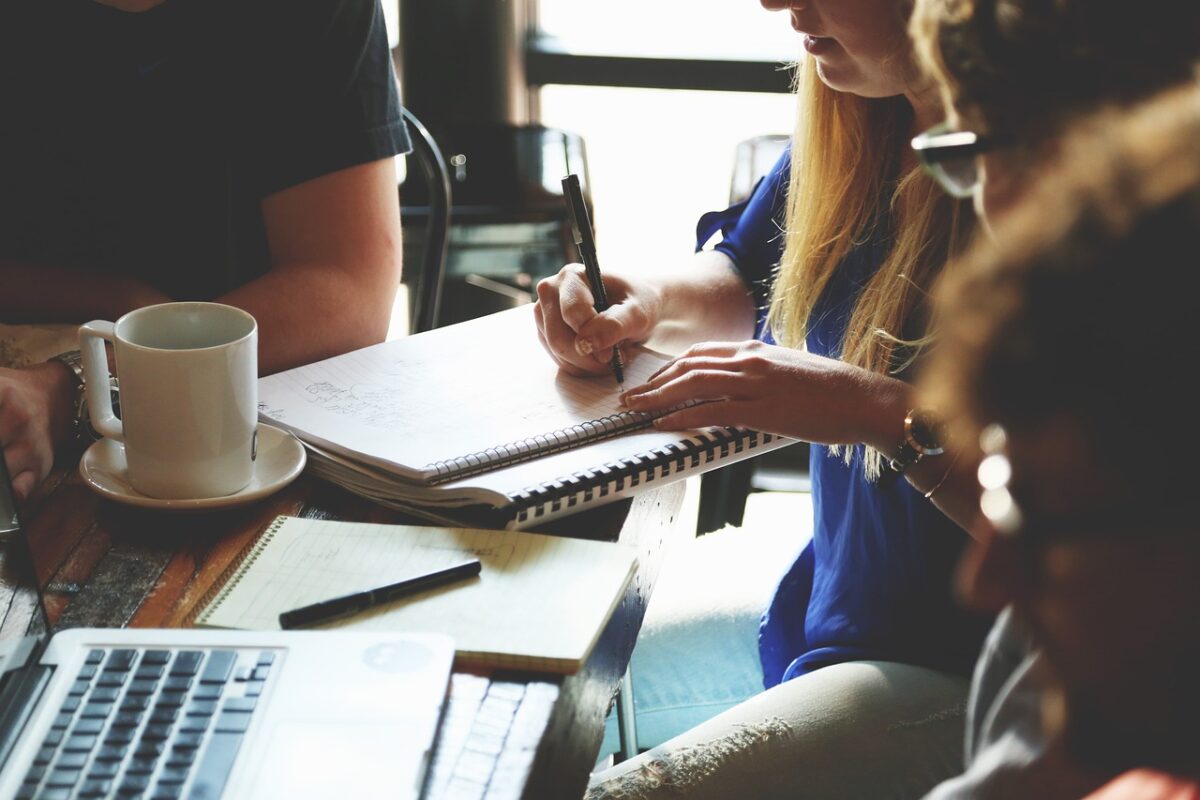 Group of people in a meeting with a woman scribing